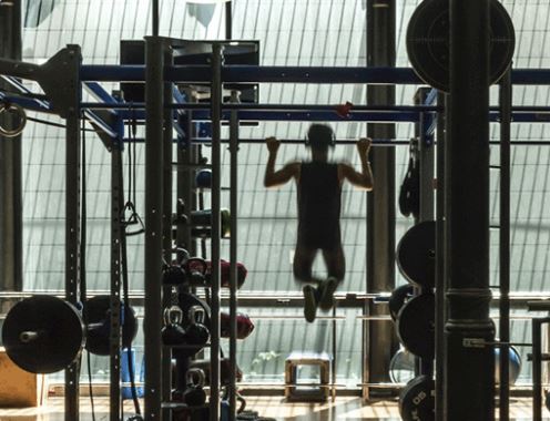 hombre haciendo dominadas en un gimnasio